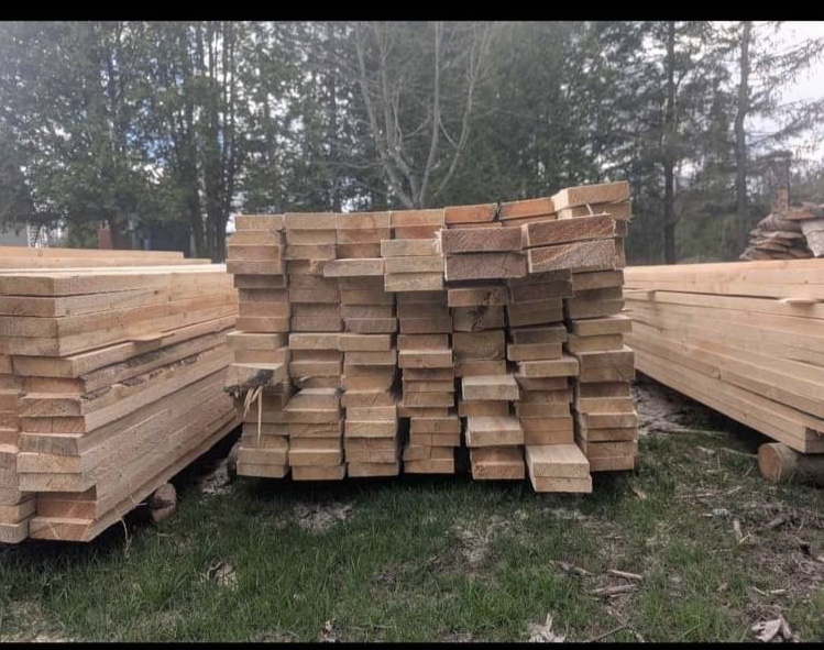 Stacks de bois de cèdre blanc scié entreposés sur la pelouse