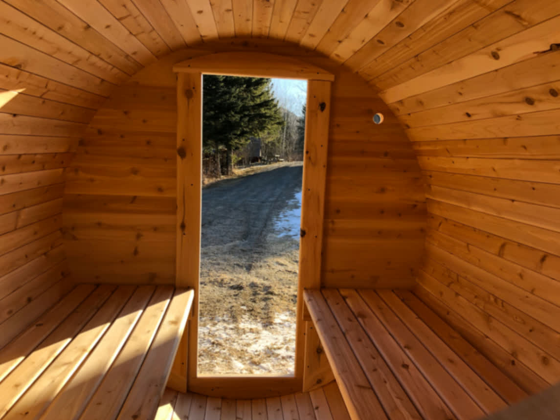 Intérieur d'un sauna baril du Québec en cèdre blanc avec porte vitrée pleine hauteur