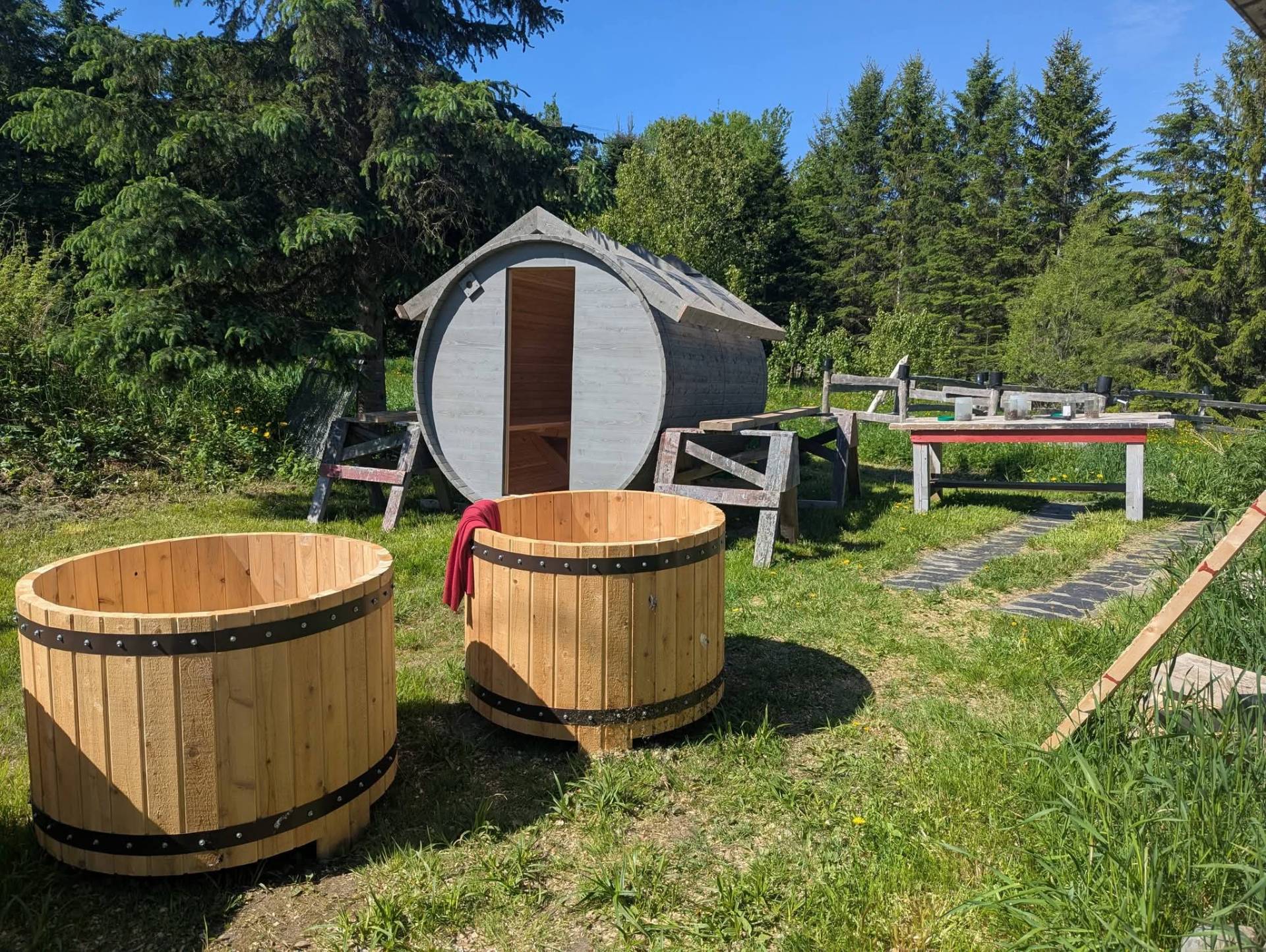 Bains nordiques en cèdre devant un sauna baril
