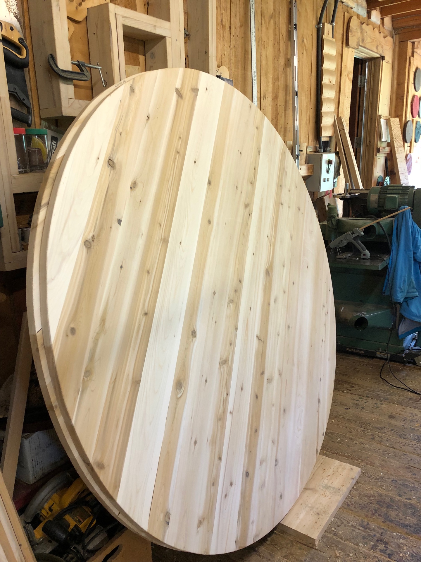 Paroi avant ovale d'un sauna baril du Québec en cèdre blanc en cours de fabrication à l'atelier